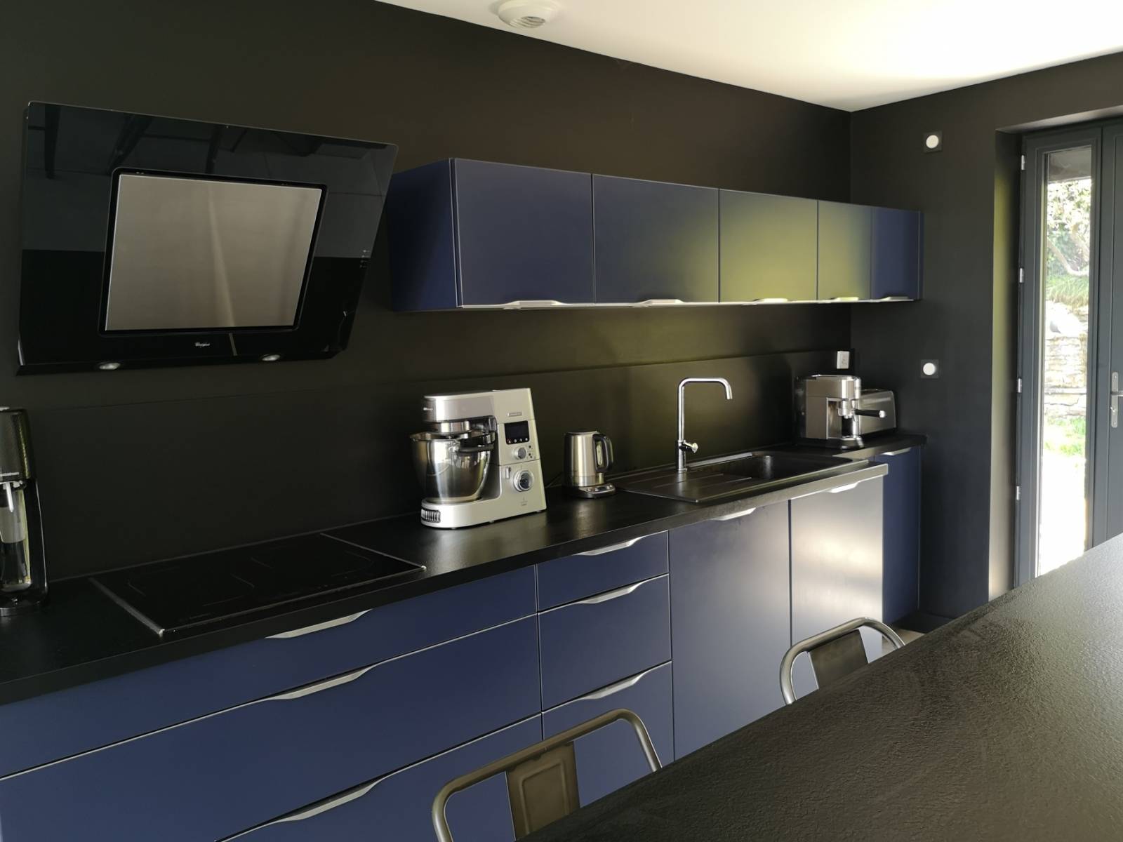 Cuisine sur mesure noire mate avec coin repas intégré - Réalisation haut de gamme Studio Creatis Caluire Lyon - Façades laquées et plan travail stratifié noir