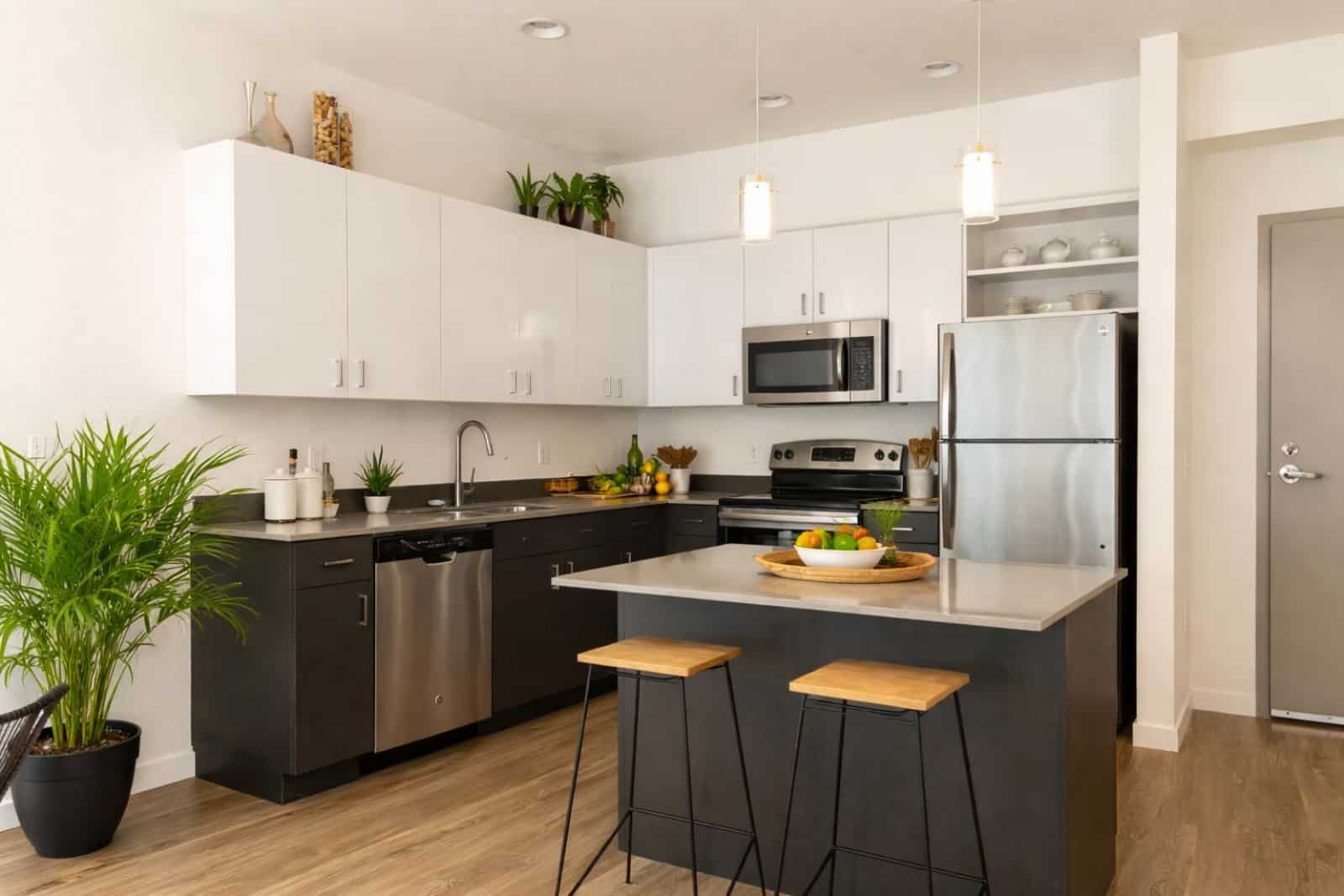 Cuisine moderne en L avec îlot central noir et blanc - Cuisiniste Lyon Caluire - Aménagement appartement contemporain