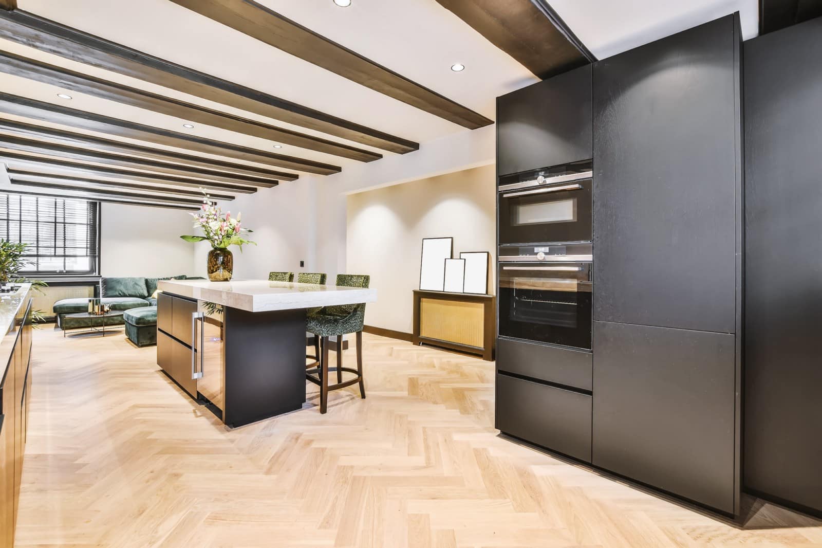 Cuisine haut de gamme avec îlot central en pierre claire et façades noires mates - Réalisation cuisiniste Caluire-et-Cuire